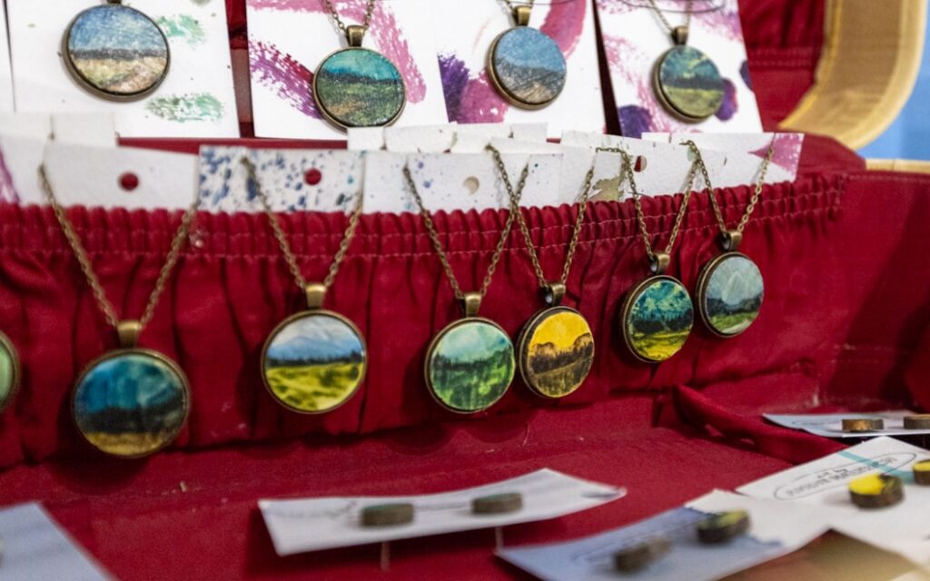 Painted pendants by Andie Haltrich in a display box